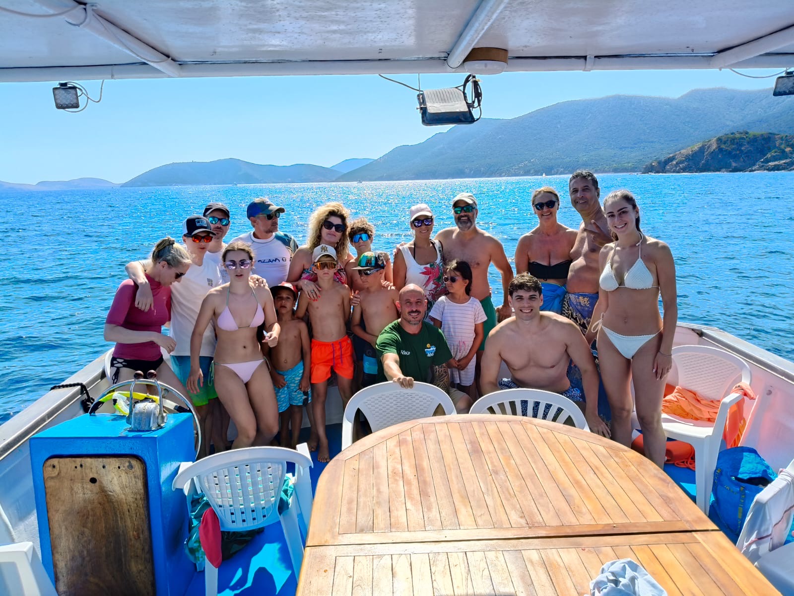 Foto di gruppo degli ospiti sorridenti a bordo della barca di Aldo